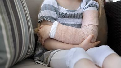 Child with arm cast after fracture treatment by pediatric orthopedic surgeon